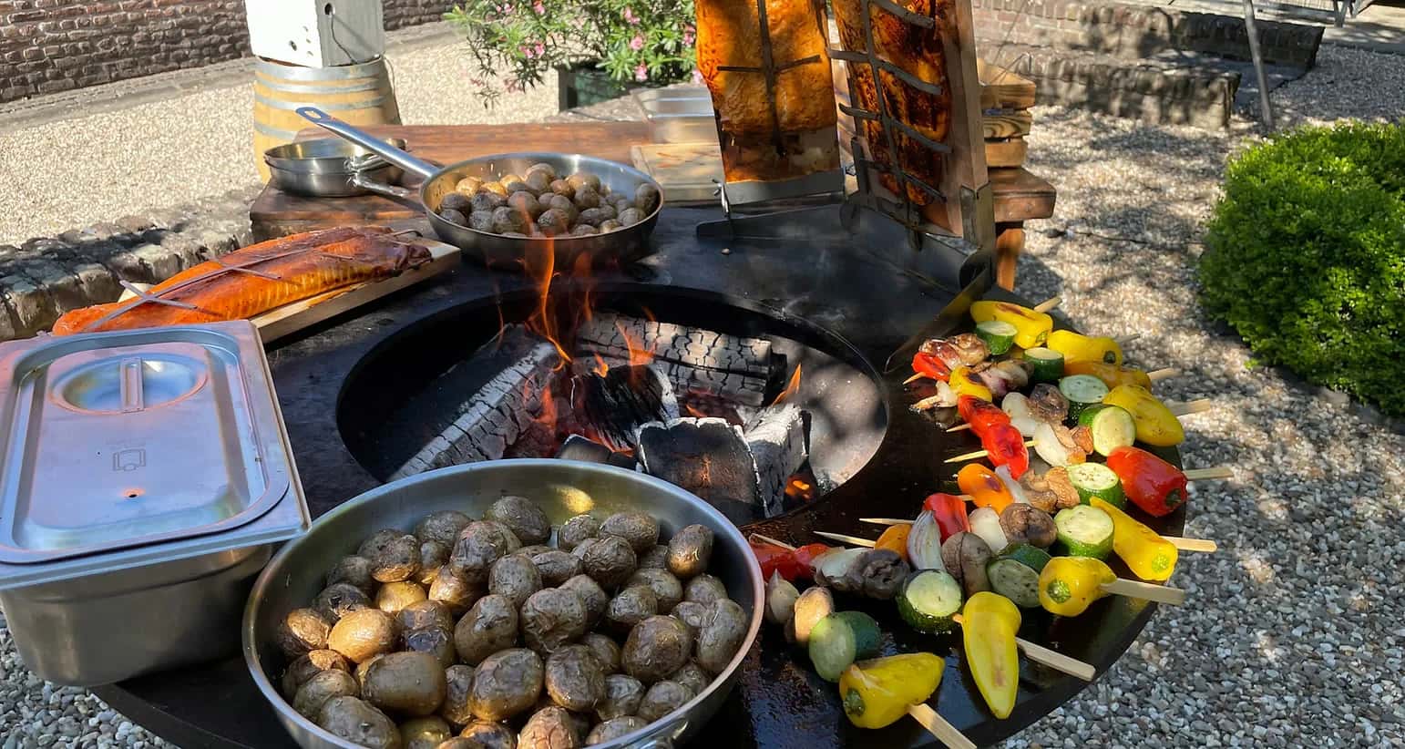 Live-Cooking mit Feuerplatte, Gemuese und Kartoffeln fuer Catering in NRW